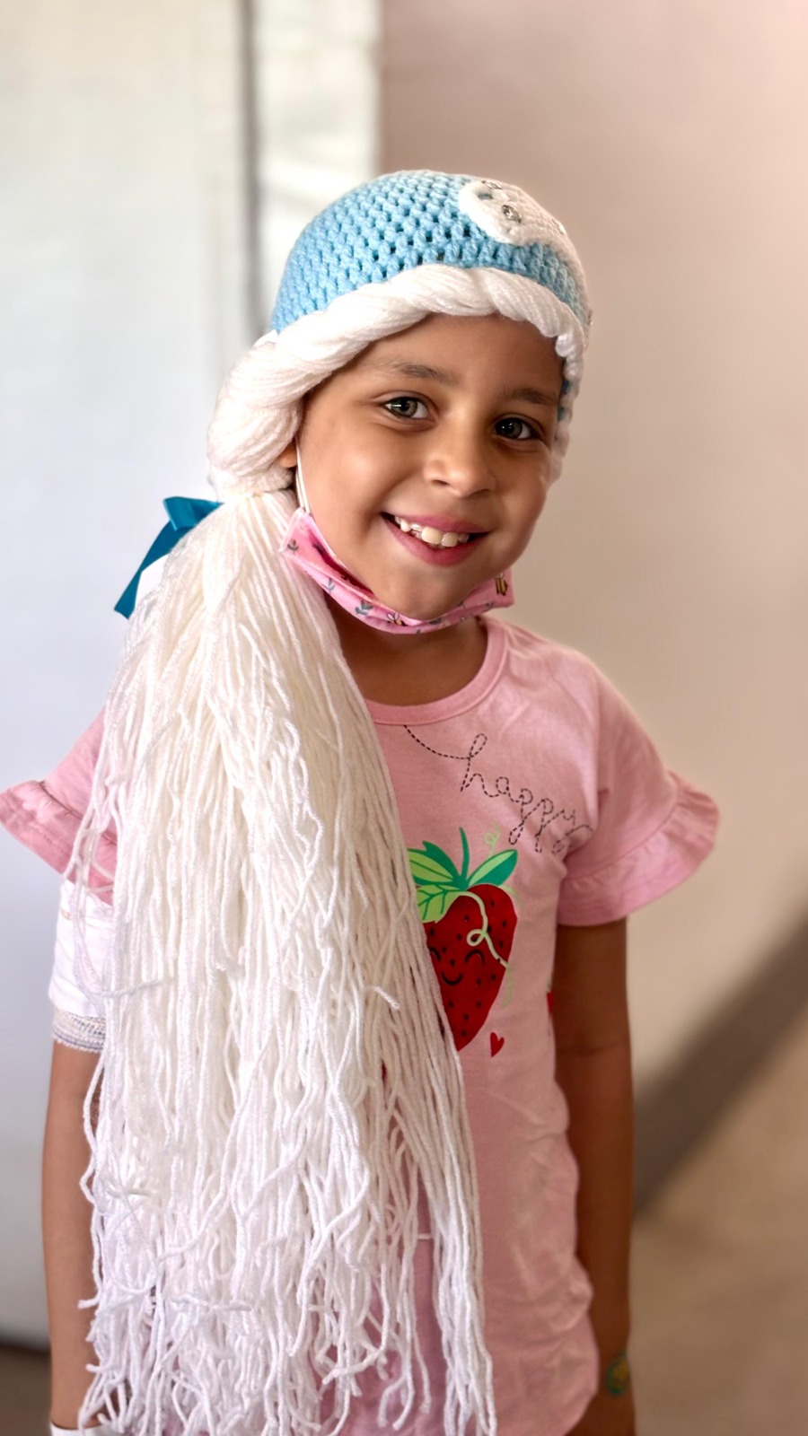 Menina sorridente em tratamento contra o câncer acolhida pela Por Amor de Muitos